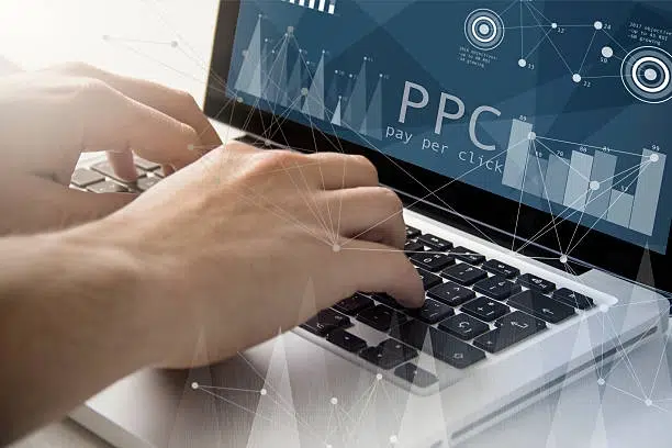 hand using laptop with ppc infographics on screen -manage ppc