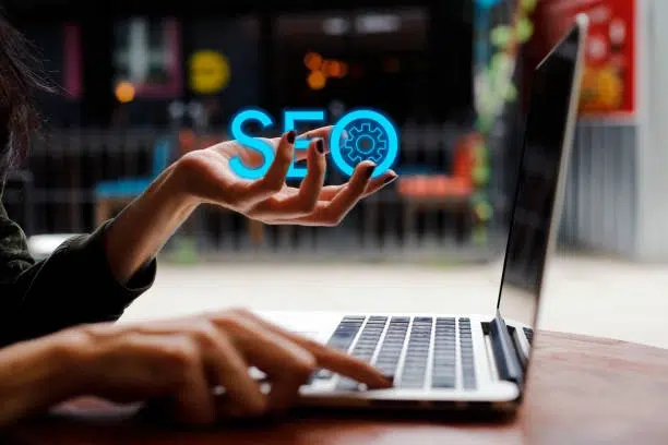 woman on laptop holding SEO letters -seo consultant services